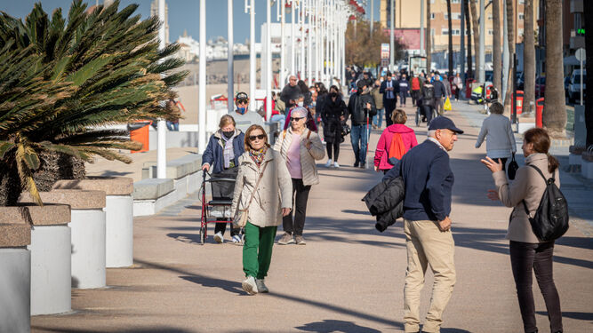Gente paseando por el paseo marítimo de Cádiz.