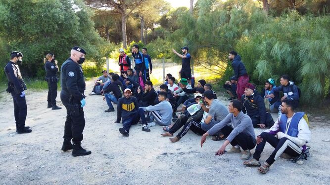 Agentes de la Policía Local custodian a la treintena de jóvenes migrantes.