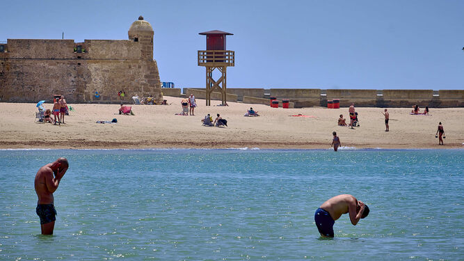 Varios bañistas en la playa de La Caleta.