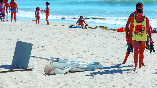 Imagen de archivo de una sombrilla derribada por el levante en la playa de Cádiz