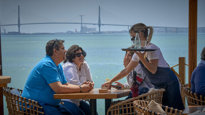 Una camarera atiende unos clientes en Puerto Sherry.