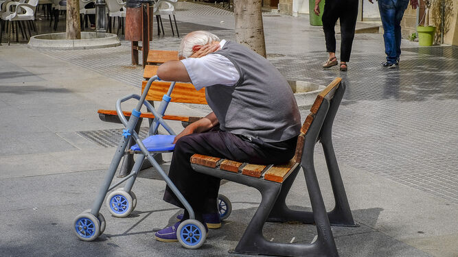 Una persona mayor sentada en la plaza de San Juan de Dios.