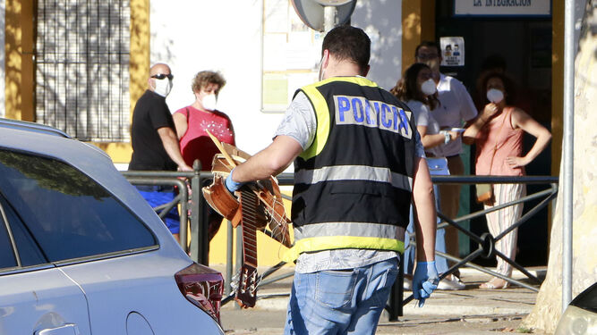 Un policía lleva una guitarra que, al parecer, fue golpeada la víctima.