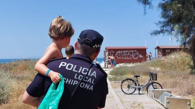 Un policía local de Chipiona, con el menor desaparecido en brazos