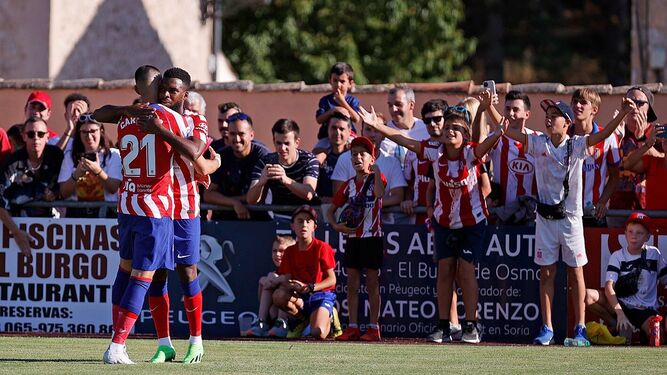 Jugadores del Atlético celebran un gol ante la alegría de los aficionados.