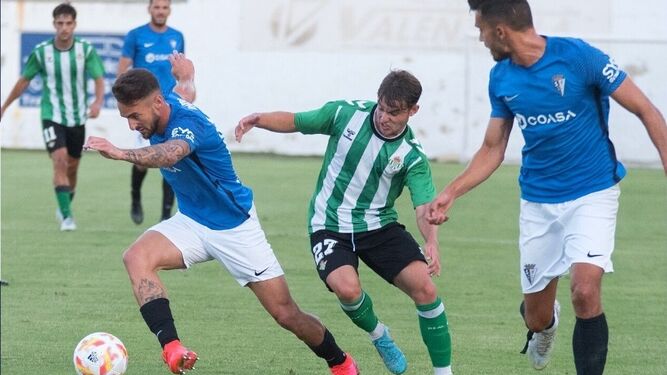Javi Navarro arranca con el balón mientras le persigue un jugador del filial verdiblanco.