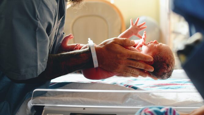 Bebé recién nacido en las manos de su madre