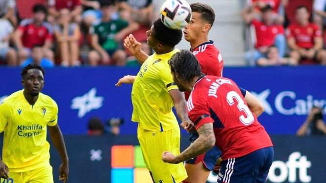 Choco Lozano salta con dos futbolista del Osasuna para alcanzar el balón.