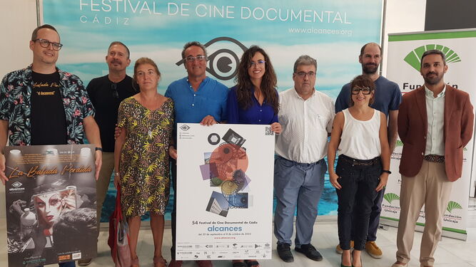Foto de familia de la presentación de la próxima edición de Alcances con el cartel oficial del festival en el centro.