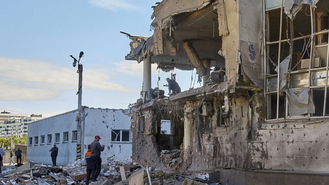 Unos ciudadanos pasan ante un edificio dañado por un ataque ruso en Jarkov.