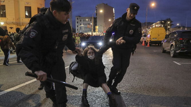 Dos agentes detienen a una manifestante en Moscú.