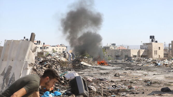 Un palestino se pone a cubierto durante los enfrentamientos con las fuerzas israelíes en Yenin.