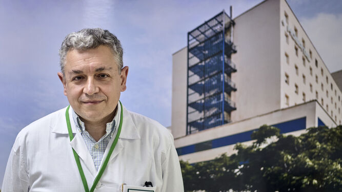 El doctor Miguel Moya, delante de una fotografía del exterior del hospital Puerta del Mar de Cádiz.