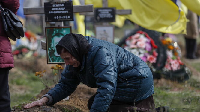 La madre de un soldado fallecido llora sobre su tumba en Jarkov.