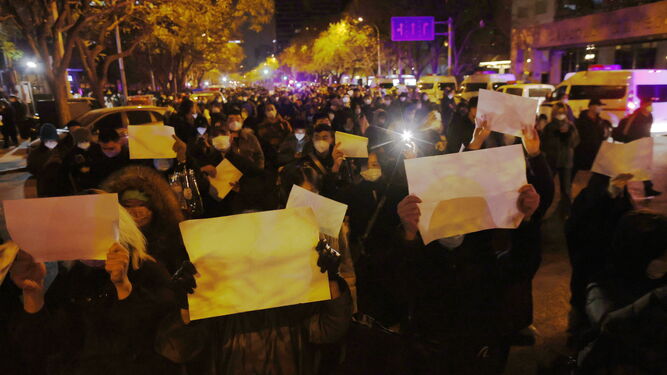 Manifestantes marchan con folios en blanco por las calles de Pekín.