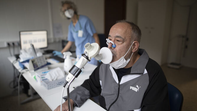 Un paciente realiza una prueba de espirometría ante la mirada de la enfermera de la Unidad Post-Covid