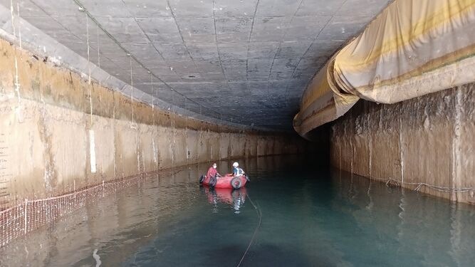 Imagen de archivo del túnel inundado en el que se ven a varios técnicos que se tienen que desplazar por su interior a bordo de una neumática.
