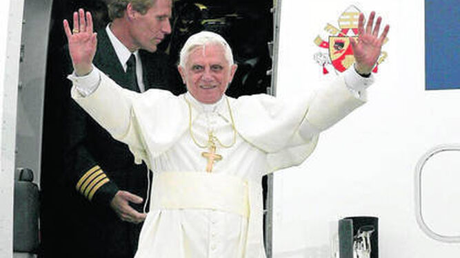 Benedicto XVI saluda desde el avión en uno de sus viajes por el mundo.