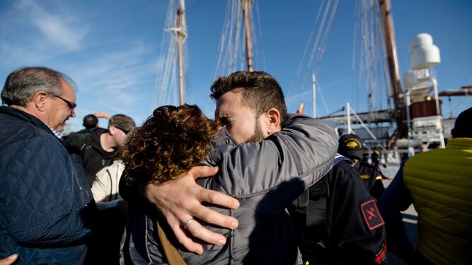 Un tripulante del Elcano se abraza a un familiar poco antes de la salida en el muelle de Cádiz.
