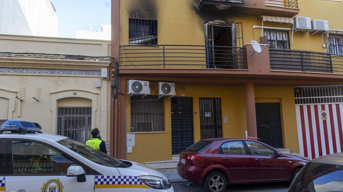 Un policía local observa la vivienda incendiada en Huelva este martes.