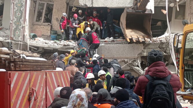 Varias personas buscan supervivientes entre los escombros.