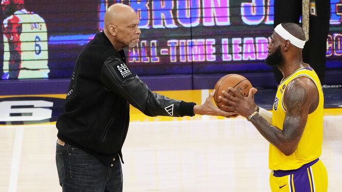 Kareem Abdul-Jabbar le pasa el balón a LeBron James tras batir su marca de anotación.