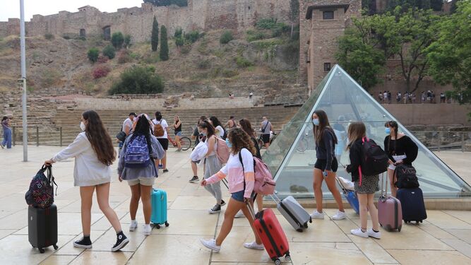 Turistas con maletas, junto al teatro romano de Málaga.