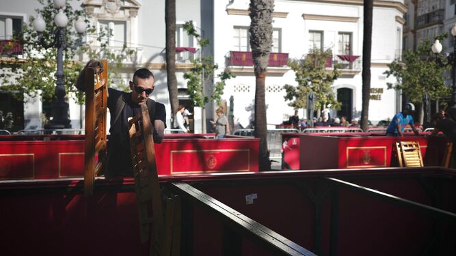 Un operario dispone las sillas en los palcos de la plaza de San Juan de Dios para este Domingo de Ramos.