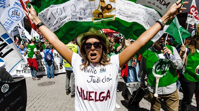 Una manifestante con la bandera de Andalucía y una inscripción en la camiseta que reza: 'Auxilio Judicial', durante la protesta.