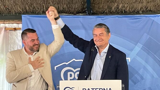 Antonio Sanz alza el brazo del candidato del PP, Andrés Clavijo, en señal de victoria.