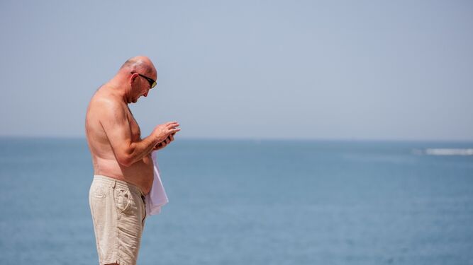 Un hombre intenta soportar el intenso calor en el Paseo Marítimo de Cádiz