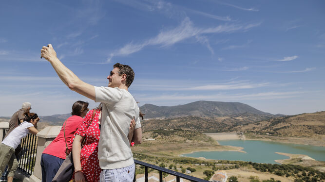 Visitantes se hacen fotos y contemplan el embalse de Zahara-El Gastor, con reservas paupérrimas a causa de la sequía.