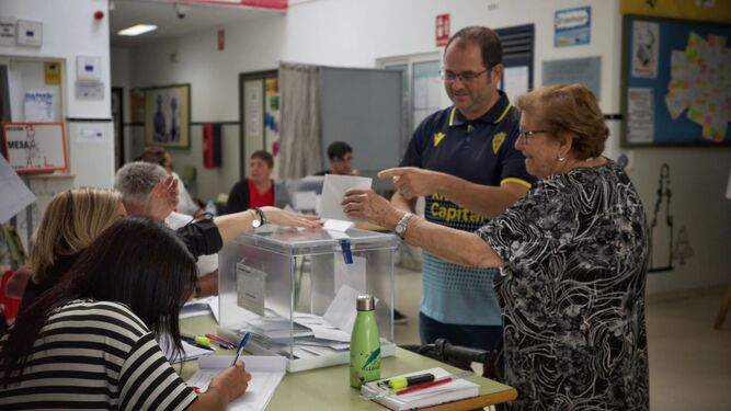 Una mujer deposita su voto en un colegio electoral en Cádiz.