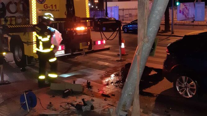Bomberos retiran un semáforo por riesgo de caída en la avenida del Puerto de Cádiz.