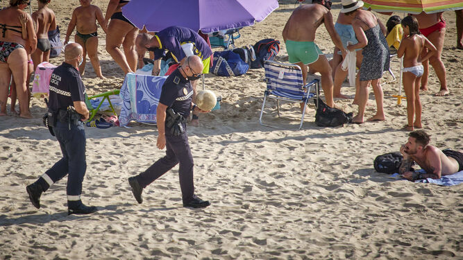 Policías locales patrullan por la arena en tiempos de pandemia.