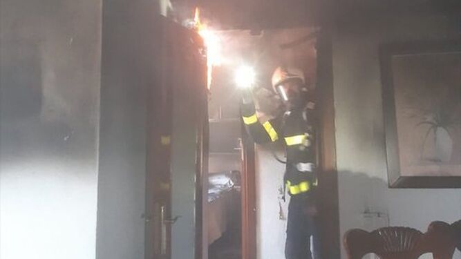 Un bombero inspecciona el interior de la vivienda calcinada en San Fernando.