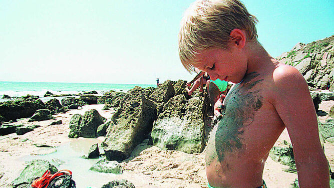 Niño con barros en la playa
