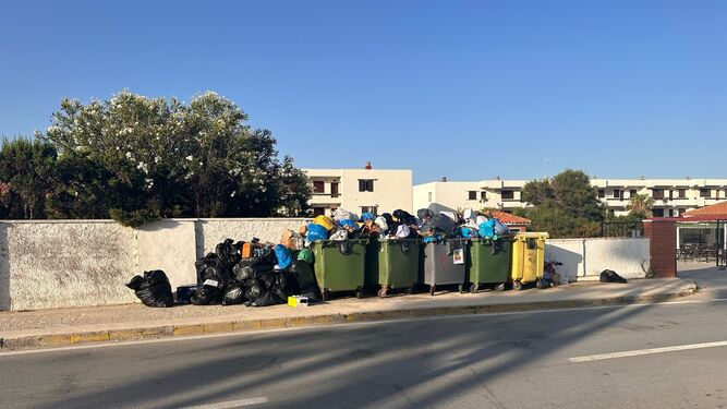 La basura sin recoger acumulada en los contenedores en Caños de Meca.