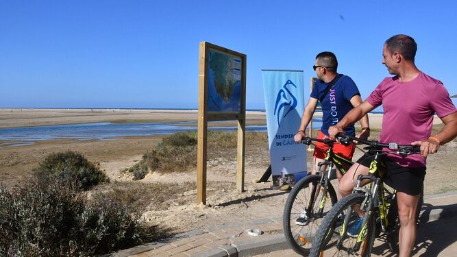 Ciclistas mirando el Mapa de Senderos de Cádiz.