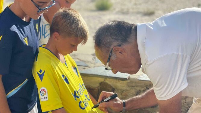 Paco Baena deja su firma en una camiseta en una de las visitas del Tour del Cádiz CF.