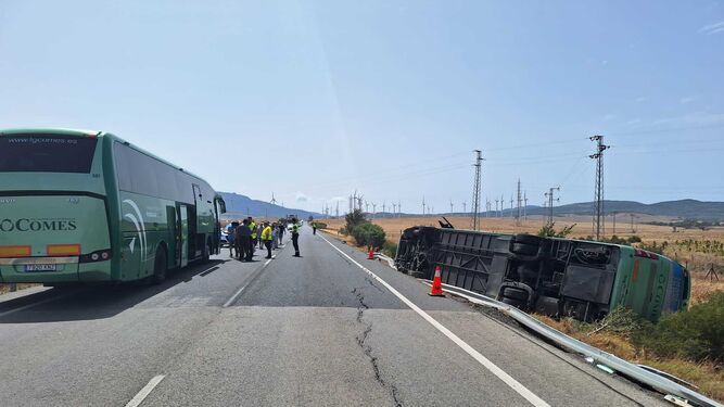 Imagen del accidente en Tarifa, con un autobús de Comes volcado.
