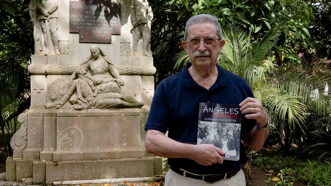 Miguel García posa con su libro junto al monumento del parque Genovés de Cádiz dedicado a la enfermera Carmen Angoloti.