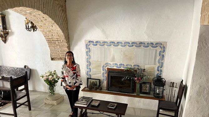 Maria Luisa de Contes, en el salón de recibo ante  una  chimenea cubierta con  azulejos hidráulicos