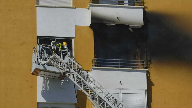 Un bombero en una escala actuando en la ventana del piso siniestrado.