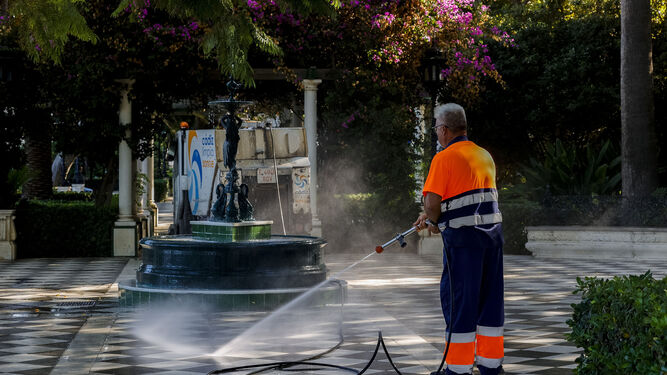 Un operario de la contrata municipal de limpieza, baldeando la Alameda con agua potable.