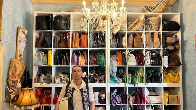 David Calleja, delante de un mueble expositor con numerosos bolsos de diferentes colores  que le da tonalidad al conjunto.