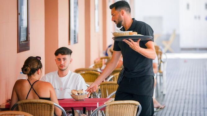 Un camarero atiende a unos clientes en el centro de Cádiz