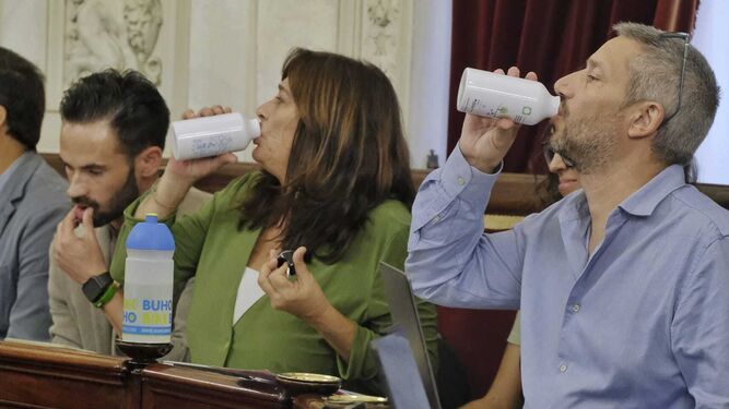 Los concejales de Adelante Izquierda Gaditana Carlos Paradas y Helena Fernández beben agua al unísono en el pleno de este jueves.