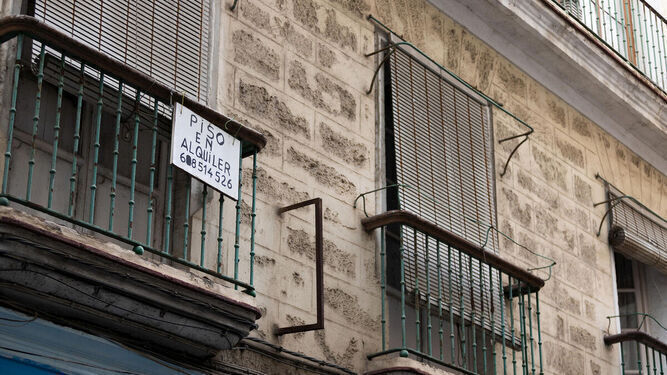 Un balcón con un cartel de piso en alquiler en el centro de Cádiz