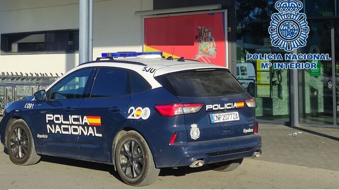 Un coche de Policía Nacional, junto al supermercado de Puerto Real donde se produjo el robo.